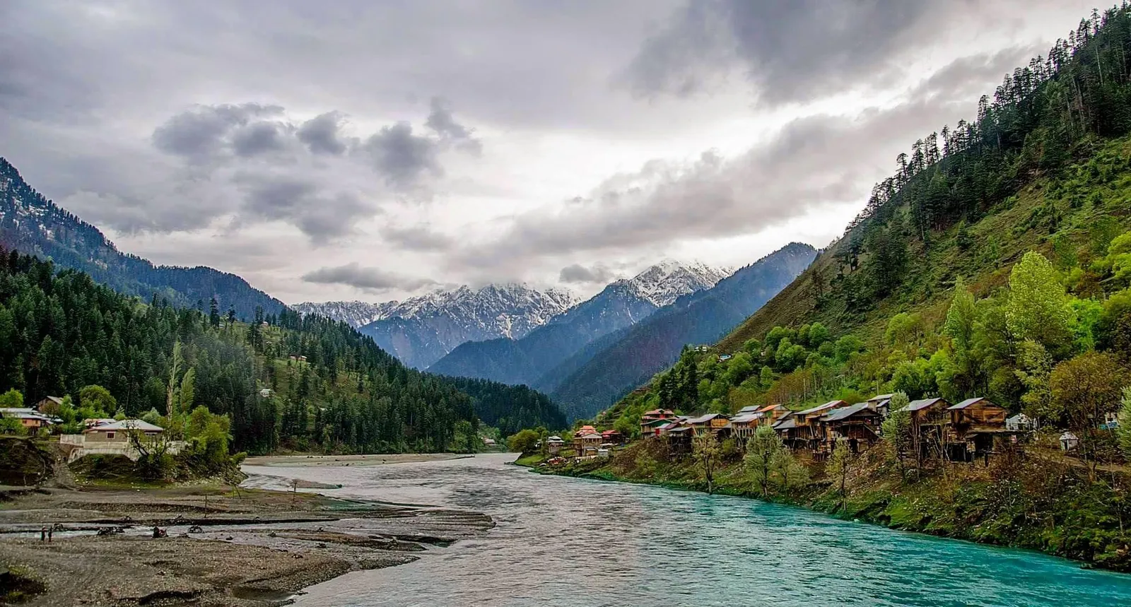 The Neelum River and wooden houses on forested slopes